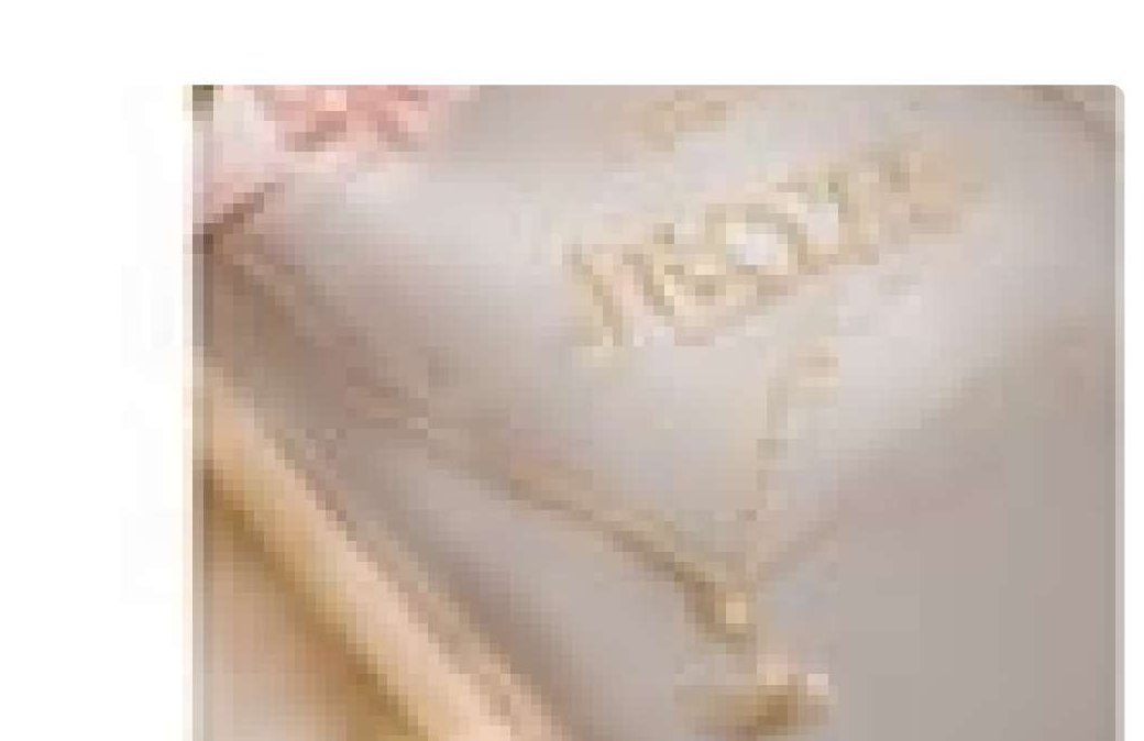 Collier délicat posé sur un coussin brodé, lumière dorée